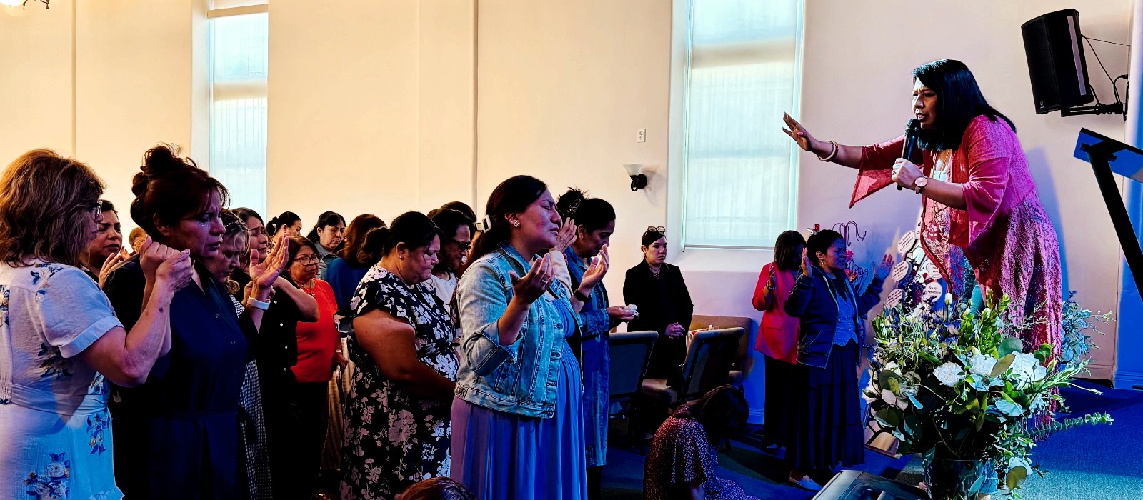 Mujeres de la congregación adorando durante un encuentro de Mujer Revestida.