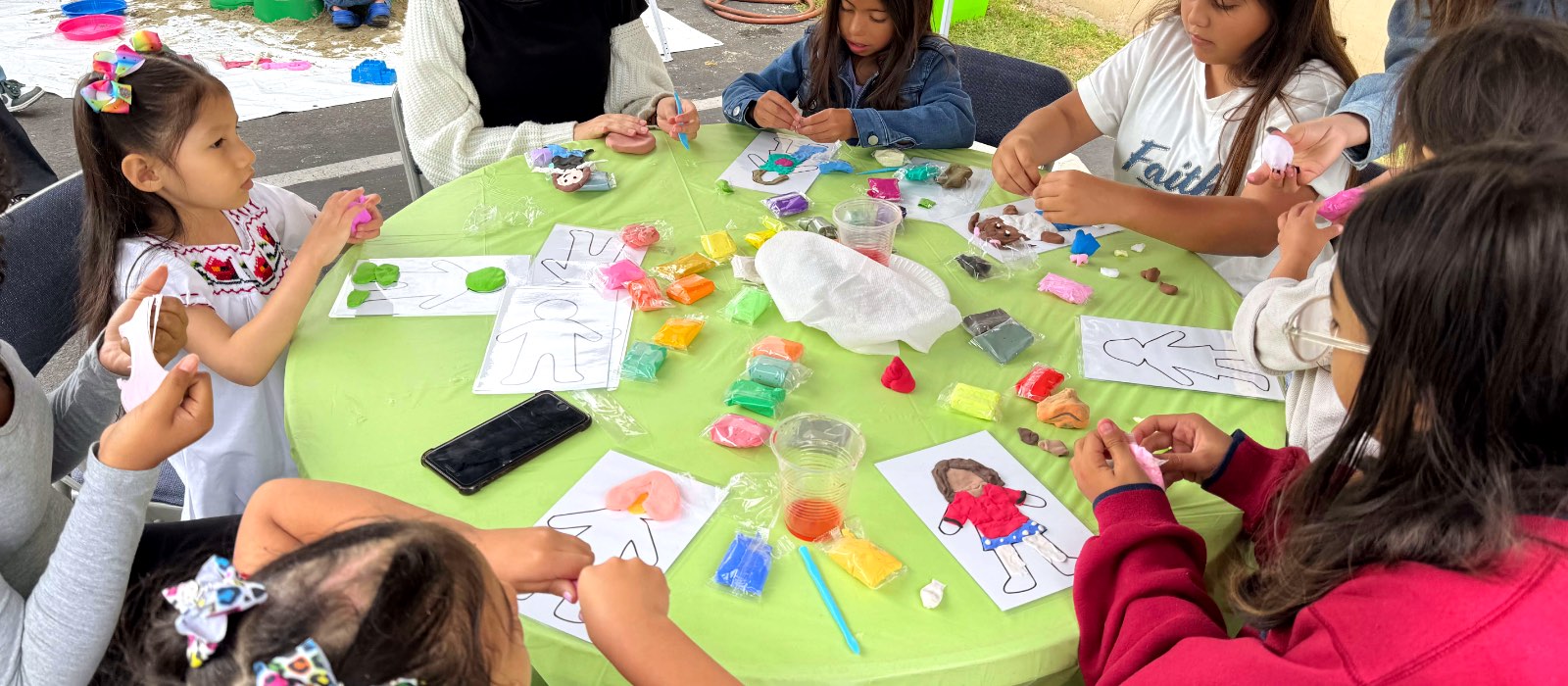 Niños haciendo manualidades alrededor de una mesa en Constructores de Fe.